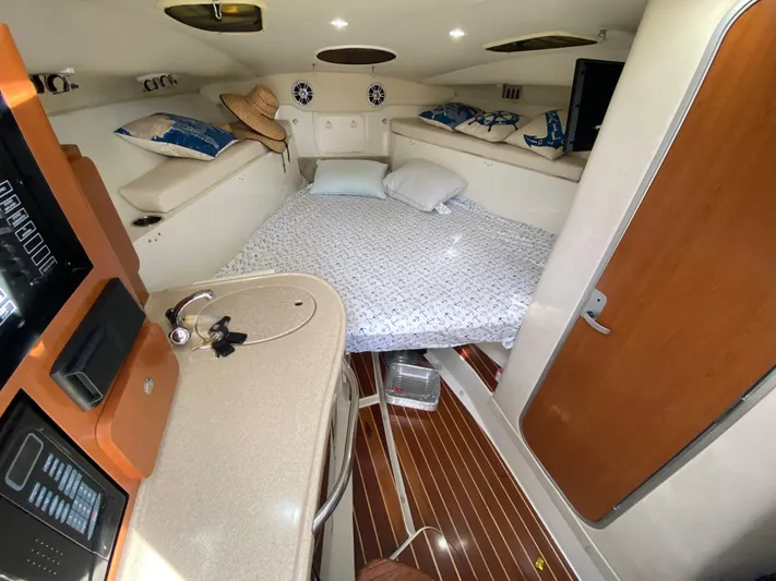  Yacht Photos Pics 2006 Hydra-Sports Vector 3300 VX cabin interior with bed, sink, and wooden flooring.