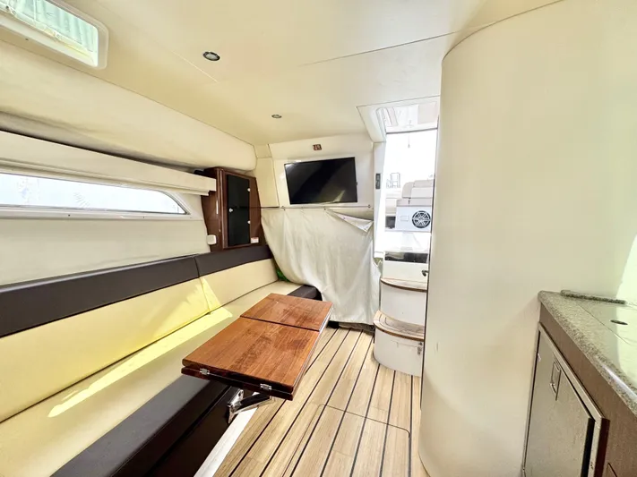 O-sea-d Yacht Photos Pics Interior of 2015 Regal 35 Sport Coupe with seating, table, and TV.
