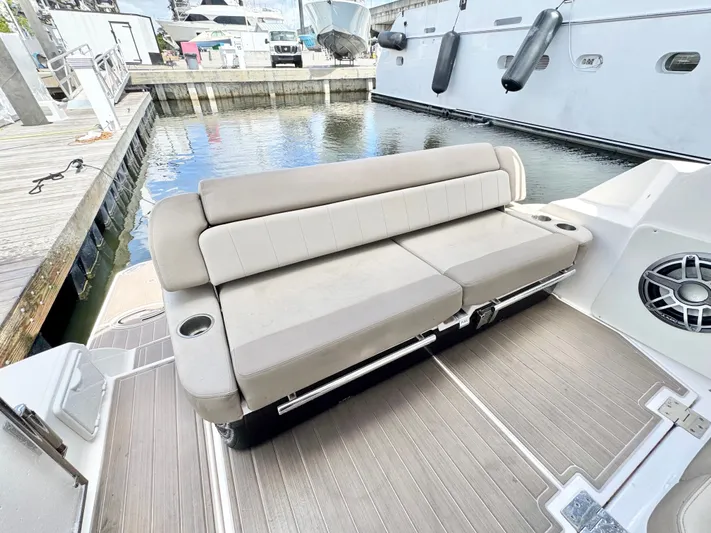 O-sea-d Yacht Photos Pics 2015 Regal 35 Sport Coupe boat with beige seating and cup holders at a marina.