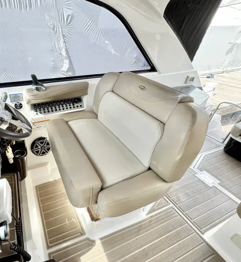 O-sea-d Yacht Photos Pics Captain's seat in 2015 Regal 35 Sport Coupe, featuring beige upholstery and control panel.