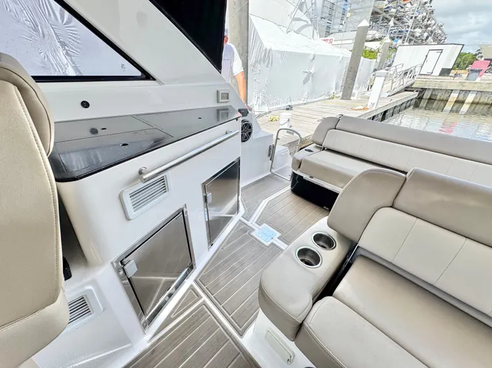 O-sea-d Yacht Photos Pics 2015 Regal 35 Sport Coupe interior with seating, cup holders, and dockside view.