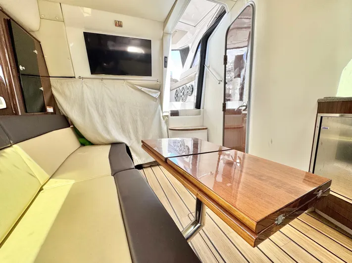 O-sea-d Yacht Photos Pics Interior of 2015 Regal 35 Sport Coupe with seating, table, and TV.