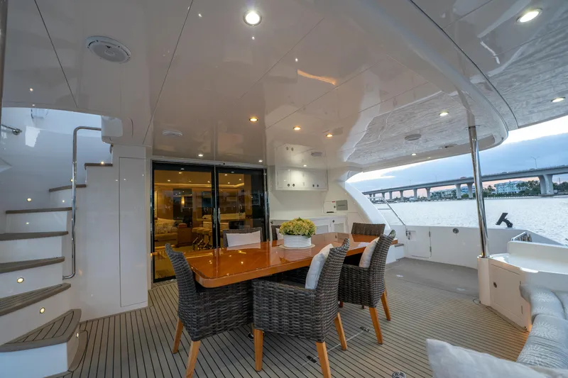 Fruition Yacht Photos Pics Luxurious Horizon PC60 yacht deck with dining area, wicker chairs, and elegant lighting, 2020 model.