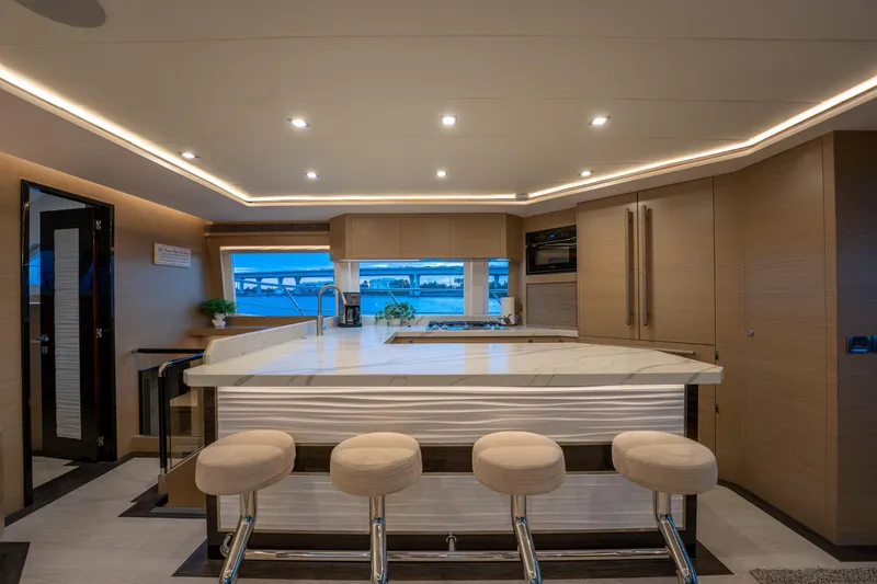 Fruition Yacht Photos Pics Luxurious yacht interior with modern kitchen, bar stools, and ambient lighting, Horizon PC60 2020 model.