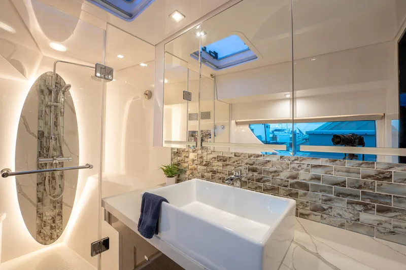 Fruition Yacht Photos Pics Luxurious yacht bathroom with modern fixtures, glass shower, and elegant tile backsplash. Horizon PC60, 2020.