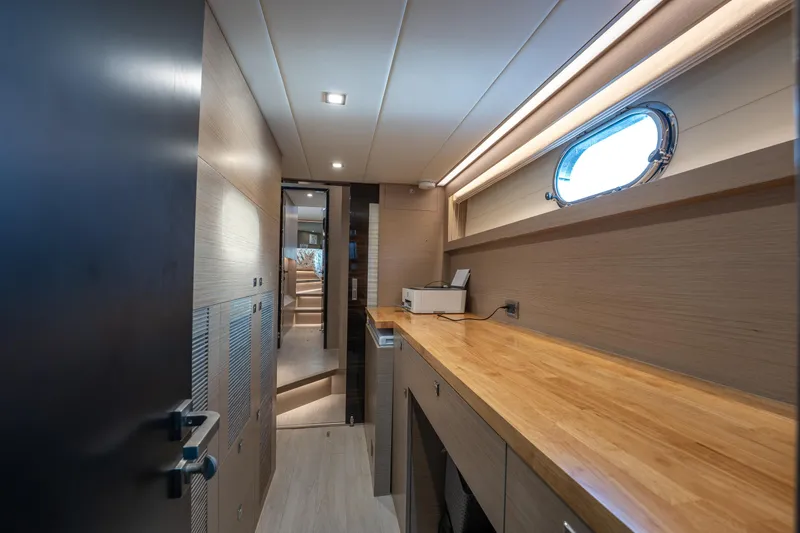 Fruition Yacht Photos Pics Modern interior of 2020 Horizon PC60 yacht with wooden cabinetry and porthole window.