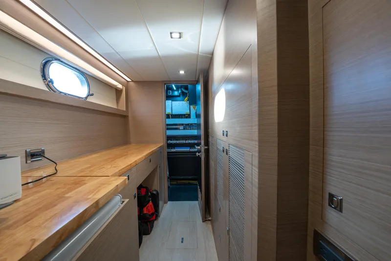 Fruition Yacht Photos Pics Modern interior of 2020 Horizon PC60 yacht with wooden cabinetry and porthole window.