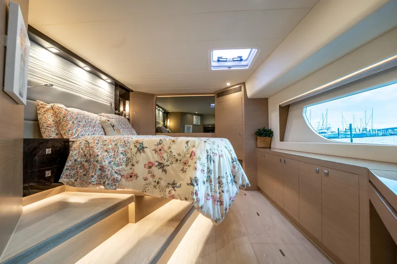 Fruition Yacht Photos Pics Luxurious bedroom interior of 2020 Horizon PC60 yacht with floral bedding and large window view.
