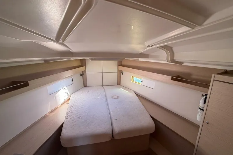 Happy Ours Yacht Photos Pics Interior cabin of 2022 Beneteau Oceanis 40.1 yacht, featuring a cozy bed and storage.