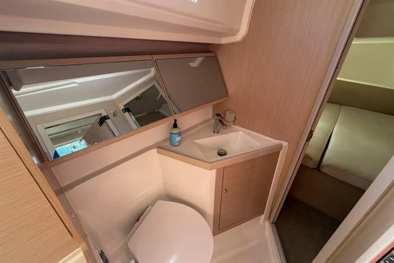 Happy Ours Yacht Photos Pics 2022 Beneteau Oceanis 40.1 yacht bathroom with sink, mirror, and toilet.