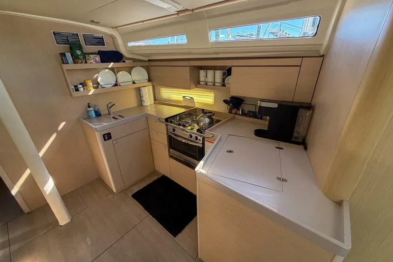 Happy Ours Yacht Photos Pics Modern kitchen interior of 2022 Beneteau Oceanis 40.1 yacht with stove and storage.
