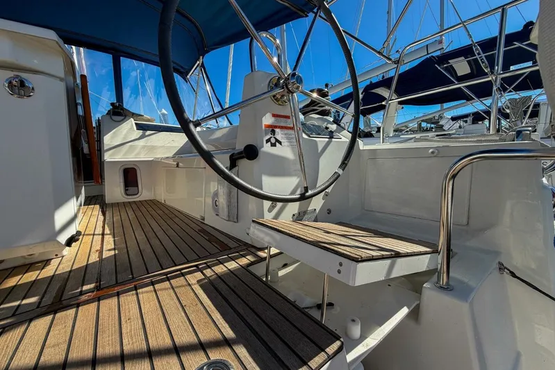 Happy Ours Yacht Photos Pics 2022 Beneteau Oceanis 40.1 yacht cockpit with wooden deck and steering wheel.