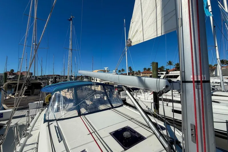 Happy Ours Yacht Photos Pics 2022 Beneteau Oceanis 40.1 sailboat docked in marina, clear blue sky background.