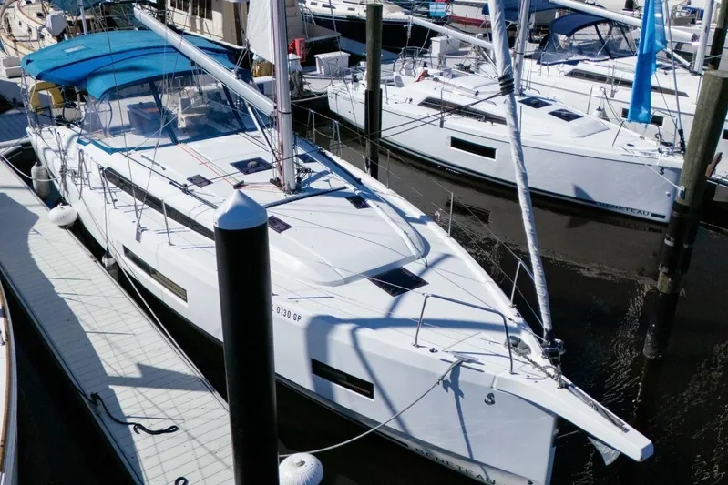 Happy Ours Yacht Photos Pics 2022 Beneteau Oceanis 40.1 sailboat docked at marina, featuring sleek design and blue canopy.