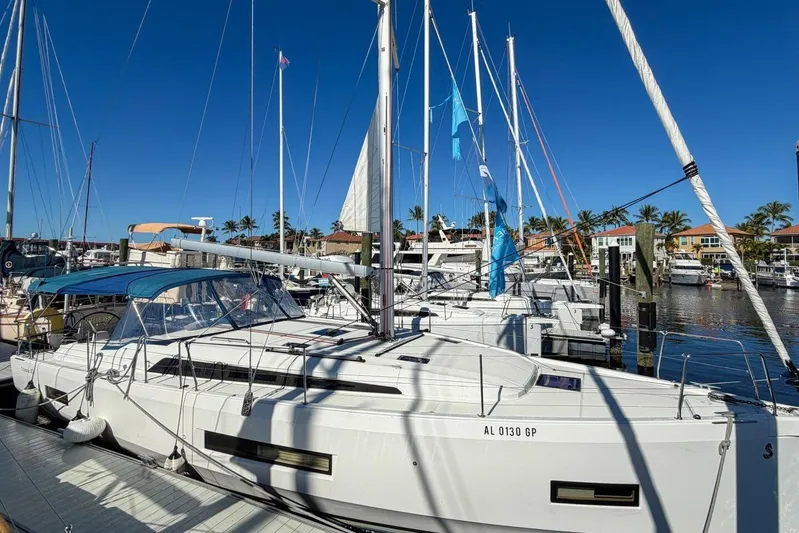 Happy Ours Yacht Photos Pics 2022 Beneteau Oceanis 40.1 sailboat docked in a sunny marina.