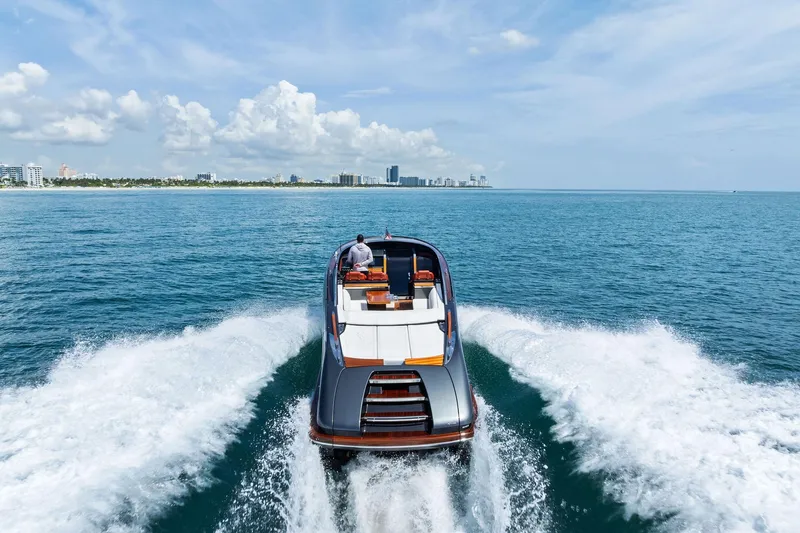 Grey Yacht Photos Pics 2023 Riva Rivamare luxury yacht cruising on open sea with city skyline.