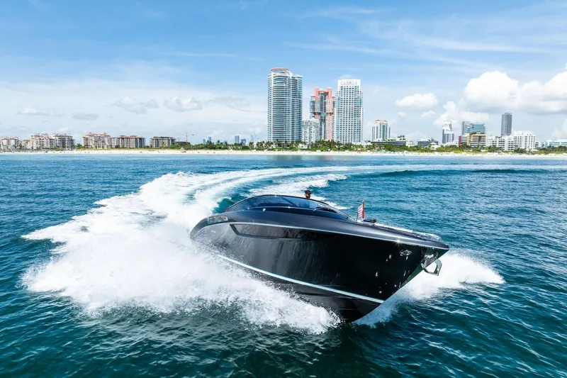 Grey Yacht Photos Pics 2023 Riva Rivamare yacht cruising near a city skyline on a sunny day.