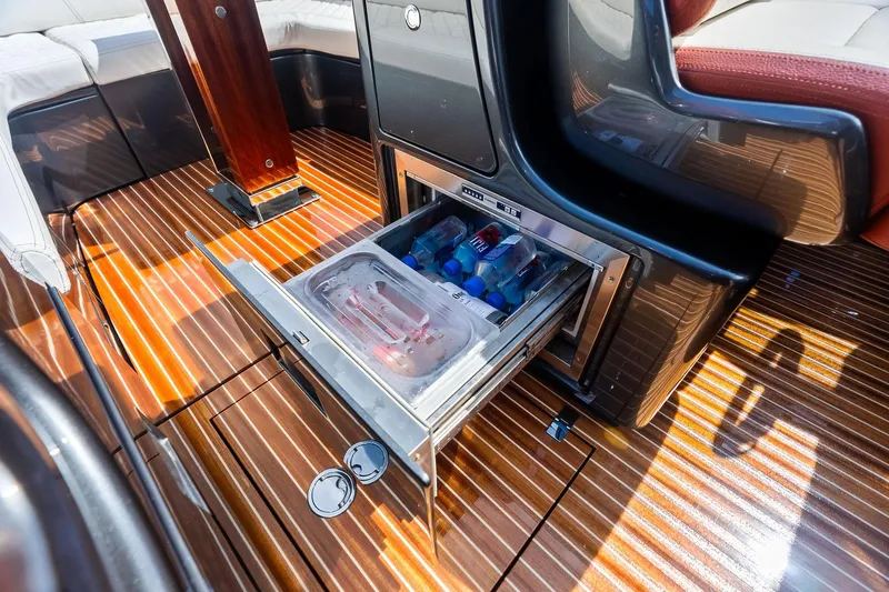 Grey Yacht Photos Pics 2023 Riva Rivamare yacht interior with open mini-fridge on sleek wooden deck.