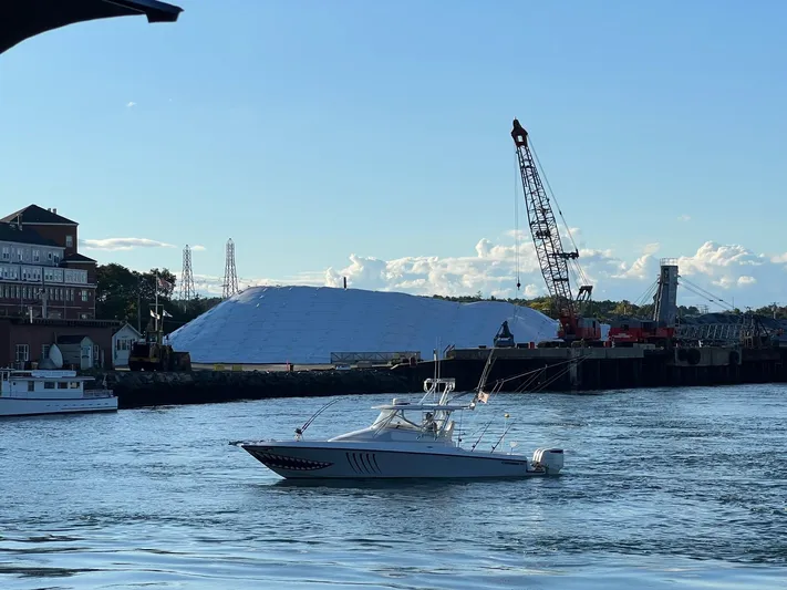 Blue Sky Yacht Photos Pics 2005 Contender 36 Fisharound boat on water near industrial dock with crane.