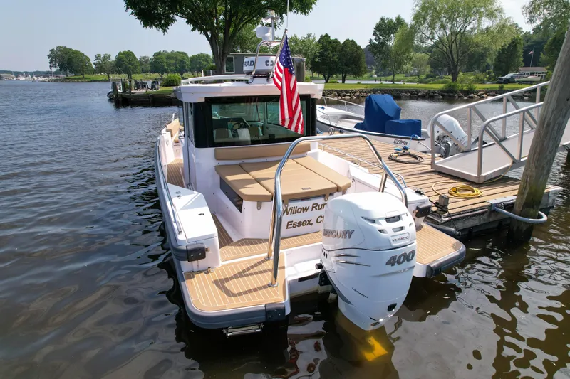 Willow Run Yacht Photos Pics 2021 Axopar 28 CABIN boat docked, featuring a Mercury 400 engine and American flag.