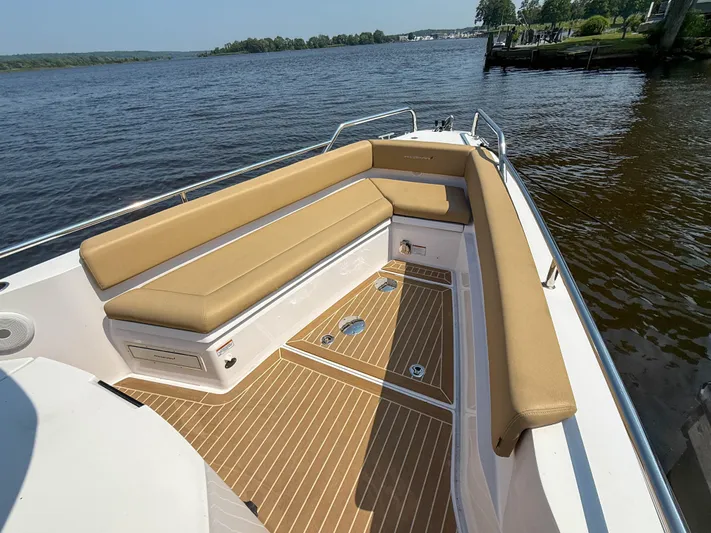 Willow Run Yacht Photos Pics Axopar 28 CABIN 2021 boat with tan seating and wooden deck on a calm lake.