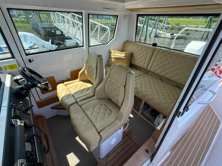 Willow Run Yacht Photos Pics Interior of 2021 Axopar 28 CABIN boat with beige quilted seating and steering wheel.