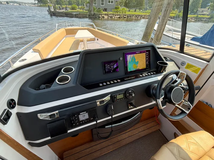 Willow Run Yacht Photos Pics 2021 Axopar 28 CABIN boat dashboard with navigation screens and steering wheel.