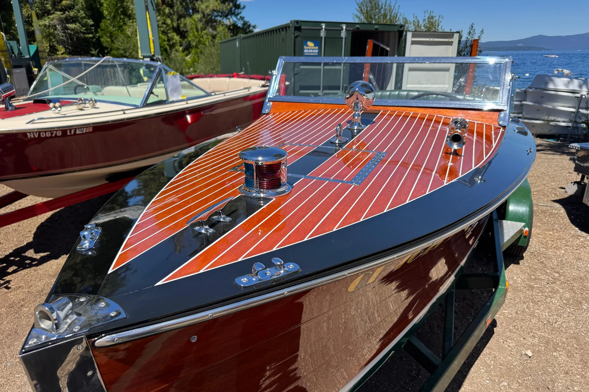 1987 Grand Craft Runabout boat with polished wood finish, docked near a lake.