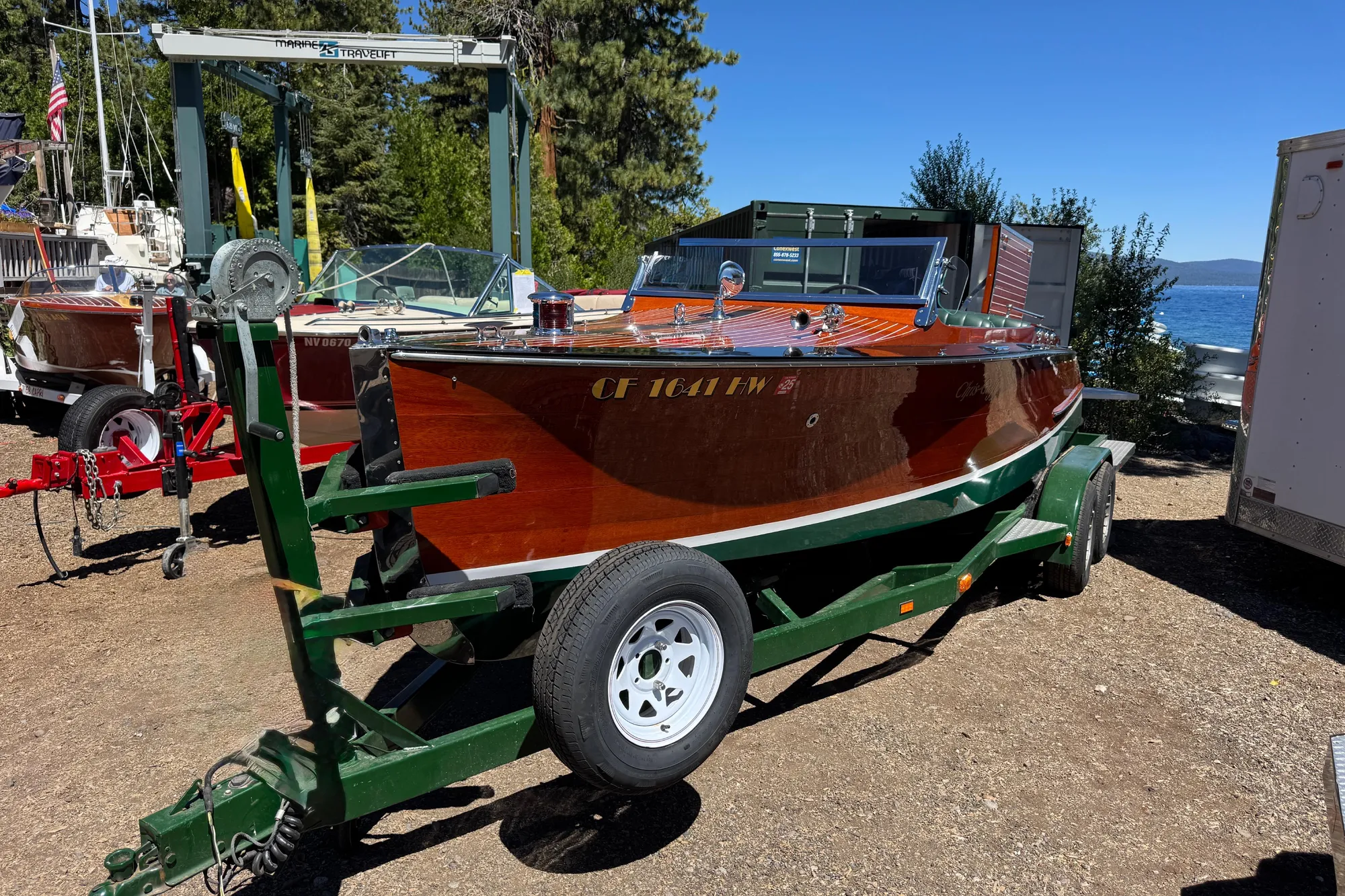 1987 Grand Craft Triple Cockpit Runabout on trailer by lakeside, surrounded by trees.