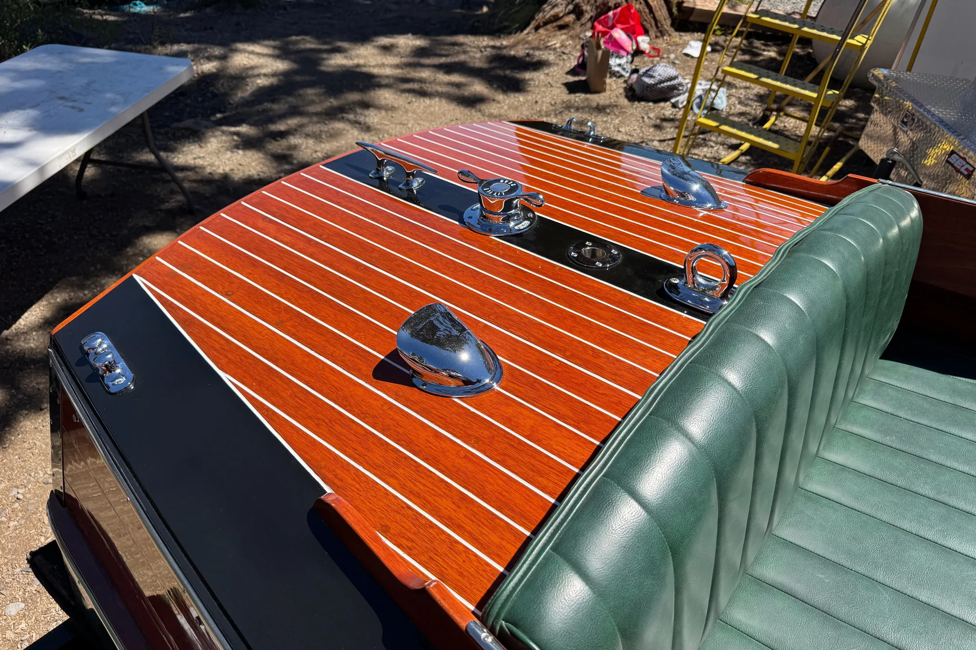1987 Grand Craft Triple Cockpit Runabout with polished wood deck and green leather seats.