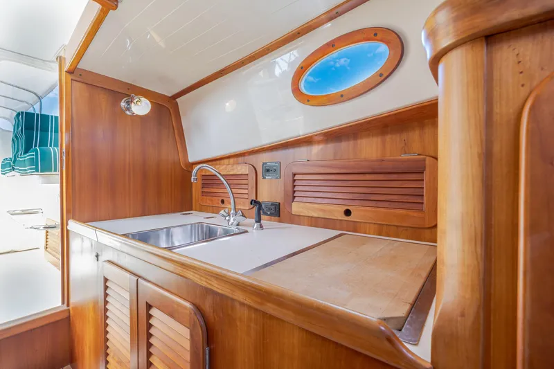 Genie Yacht Photos Pics Interior of 1999 Hinckley Picnic Boat with wooden cabinetry and stainless steel sink.
