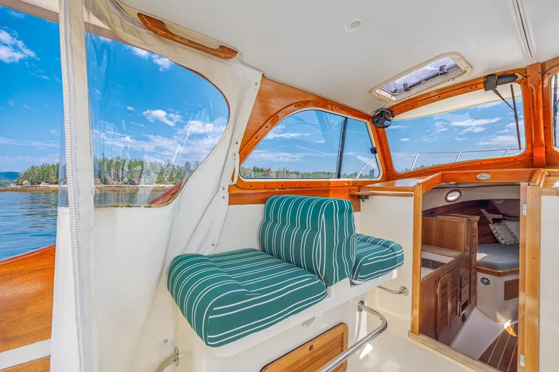 Genie Yacht Photos Pics Interior of a 1999 Hinckley Picnic Boat with striped seating and scenic water view.