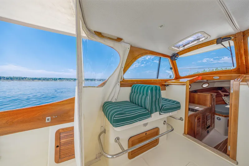 Genie Yacht Photos Pics Interior of a 1999 Hinckley Picnic Boat with striped seating and scenic water view.