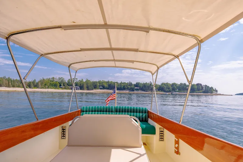 Genie Yacht Photos Pics 1999 Hinckley Picnic Boat cruising on serene waters with canopy and American flag.