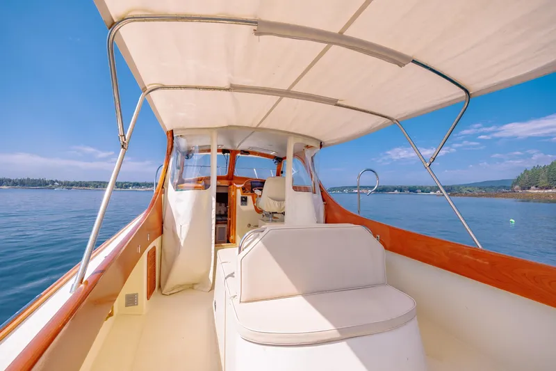 Genie Yacht Photos Pics 1999 Hinckley Picnic Boat interior with canopy, cruising on calm waters under a clear blue sky.