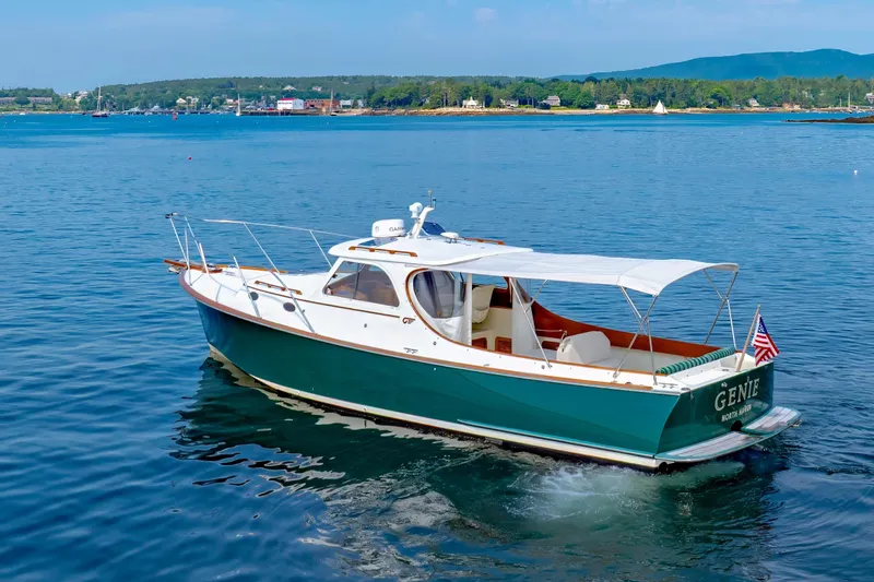 Genie Yacht Photos Pics 1999 Hinckley Picnic Boat cruising on calm waters with scenic shoreline backdrop.