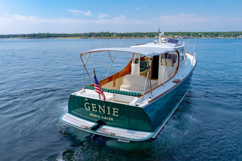 Genie Yacht Photos Pics 1999 Hinckley Picnic Boat on calm water, featuring elegant design and American flag.