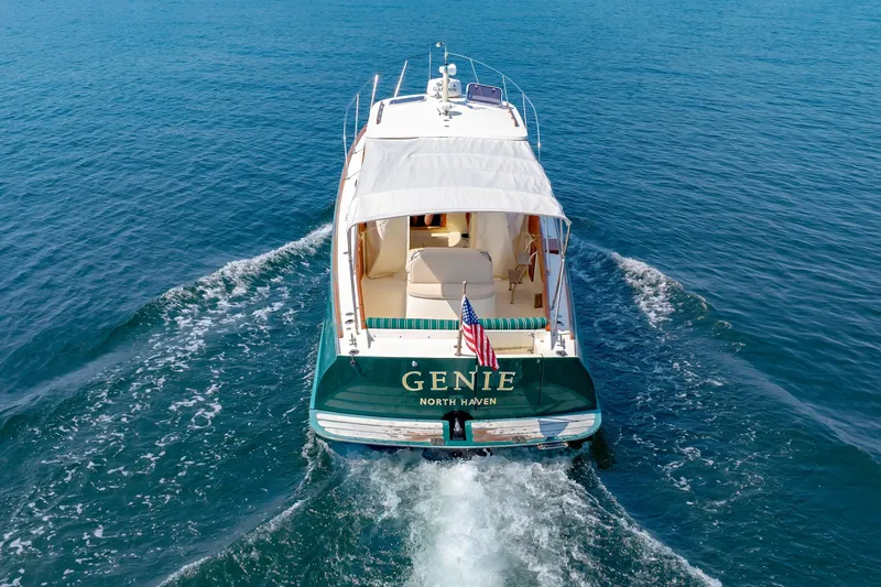 Genie Yacht Photos Pics 1999 Hinckley Picnic Boat cruising on open water, rear view with American flag.