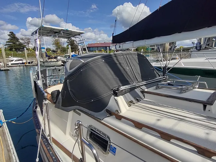 Wu Wei Yacht Photos Pics 1997 Pacific Seacraft 37 sailboat docked at marina, featuring sleek design and covered cockpit.