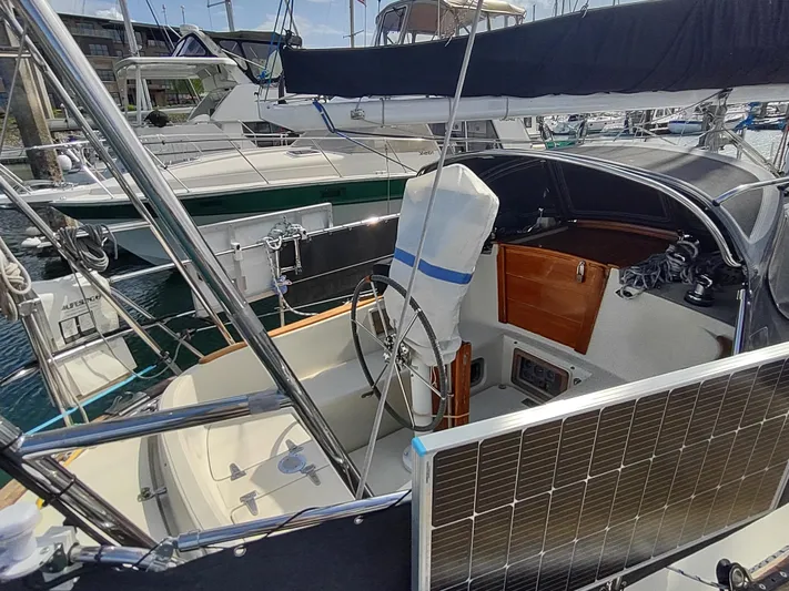 Wu Wei Yacht Photos Pics 1997 Pacific Seacraft 37 sailboat cockpit with solar panel and steering wheel.