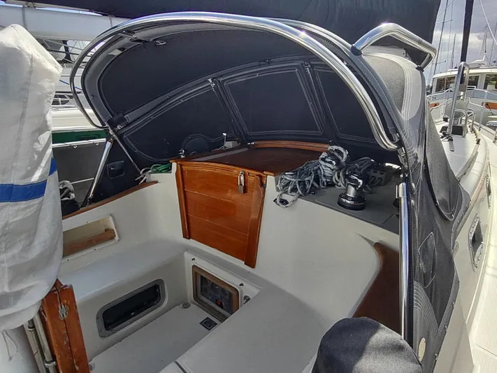 Wu Wei Yacht Photos Pics 1997 Pacific Seacraft 37 sailboat cockpit with wooden hatch and covered helm.