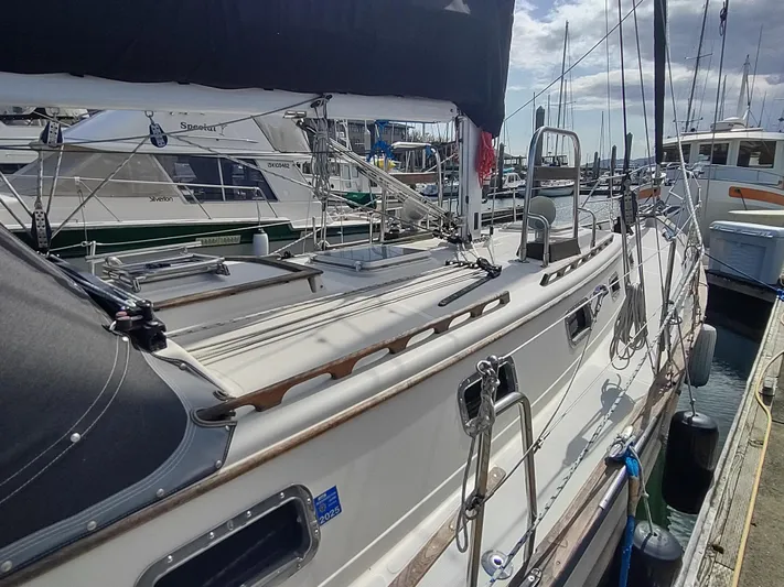 Wu Wei Yacht Photos Pics 1997 Pacific Seacraft 37 sailboat docked at a marina under a partly cloudy sky.