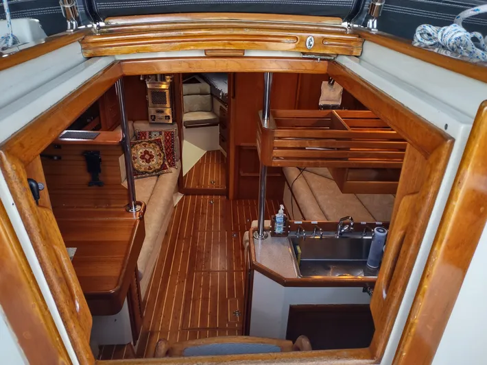 Wu Wei Yacht Photos Pics Interior view of a 1997 Pacific Seacraft 37 sailboat, featuring wood finishes and cozy seating.