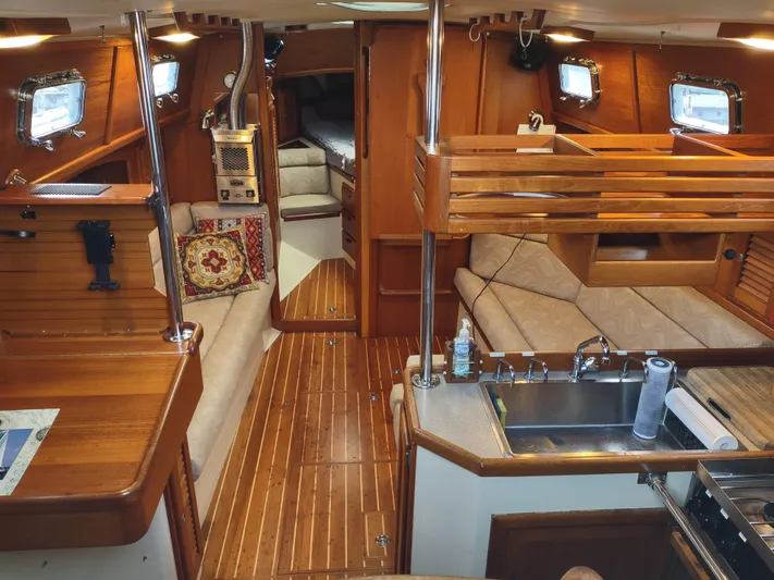 Wu Wei Yacht Photos Pics Interior of a 1997 Pacific Seacraft 37 sailboat, featuring wood finishes and cozy seating.