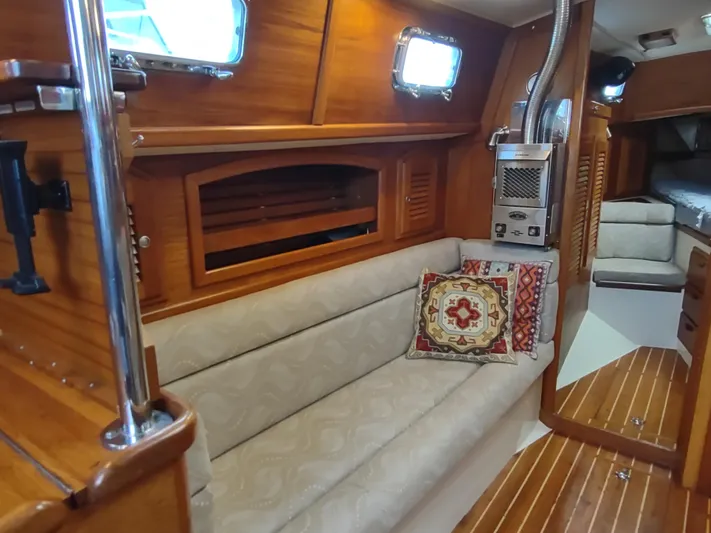 Wu Wei Yacht Photos Pics Interior of 1997 Pacific Seacraft 37 sailboat with cozy seating and wooden accents.