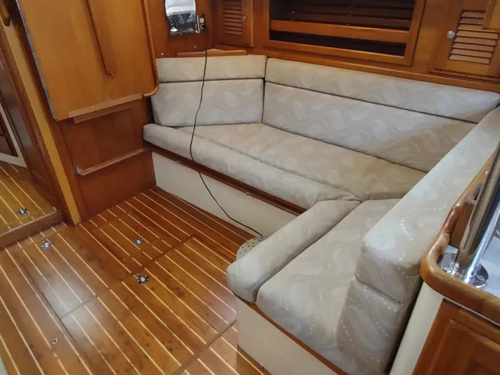 Wu Wei Yacht Photos Pics Interior of 1997 Pacific Seacraft 37 sailboat with wooden flooring and cushioned seating.