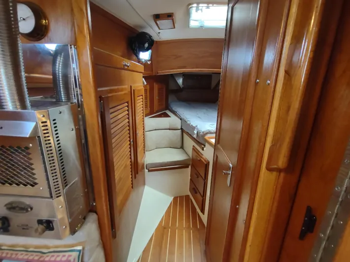 Wu Wei Yacht Photos Pics Interior of 1997 Pacific Seacraft 37 sailboat with wooden cabinetry and cozy sleeping area.