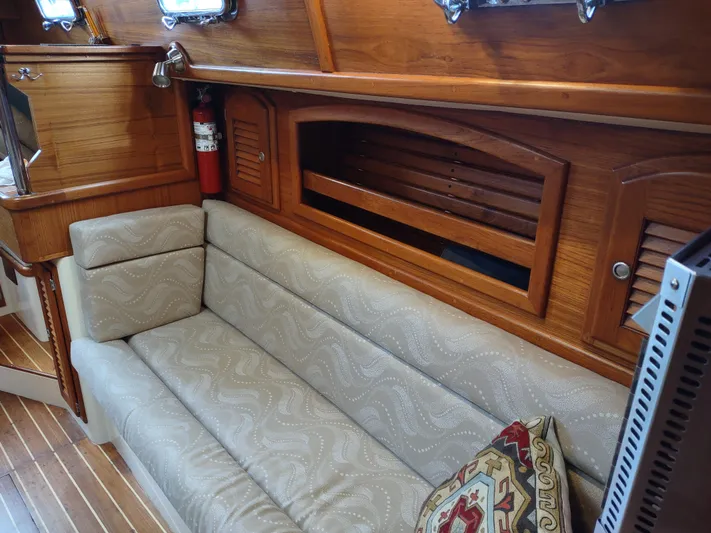 Wu Wei Yacht Photos Pics Cozy interior of 1997 Pacific Seacraft 37 sailboat with wooden accents and cushioned seating.