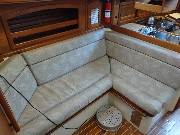 Wu Wei Yacht Photos Pics Cozy interior seating on a 1997 Pacific Seacraft 37 sailboat with patterned cushions.