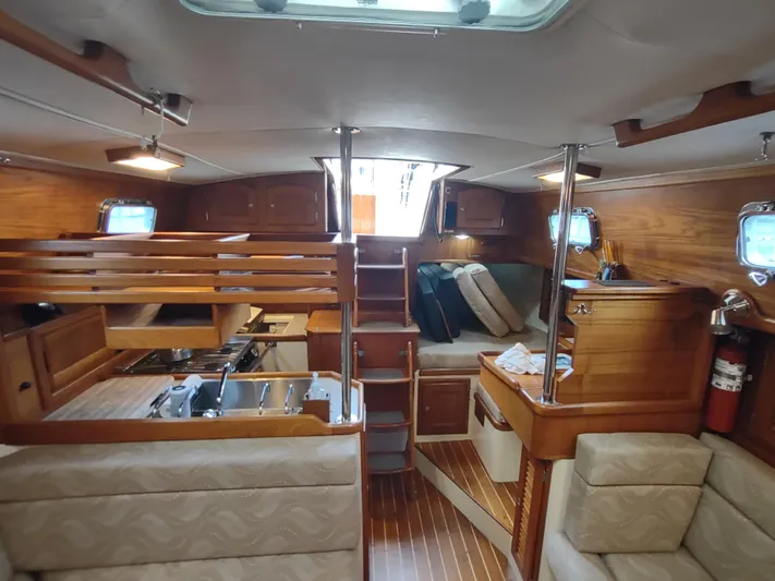 Wu Wei Yacht Photos Pics Interior of 1997 Pacific Seacraft 37 sailboat with wood finish and cozy seating area.